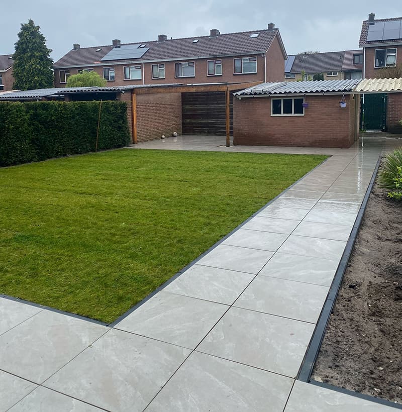 Aanleg achtertuin met keramische tegels en graszoden in Ermelo